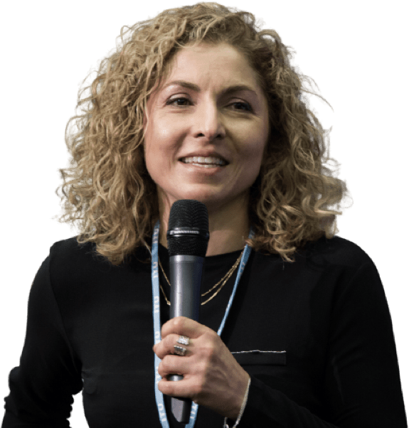 Flight Engineer Anousheh Ansari, a blond brownish curly haired woman in a black top, holding a microphone ready to start speaking.