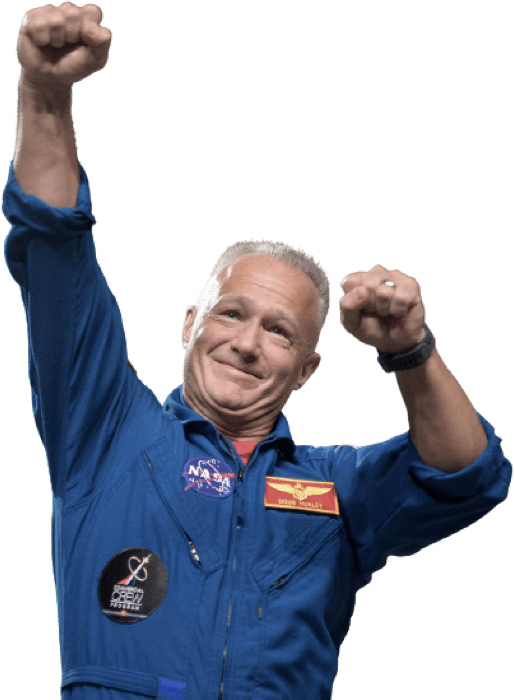 The commander Douglas Hurley in a blue NASA  outfit, celebrating with both fists in the air the left hand higher than the right.